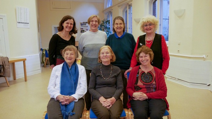Auf dem Bild ist eine Gruppe von fröhlichen Seniorinnen im Saal der Gemeinde Zum Guten Hirten zu sehen.