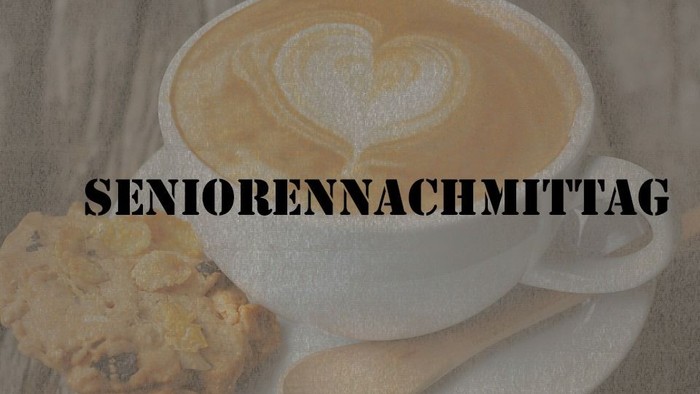 Ein Latte Macchiato mit Herzverzierung und ein Keks auf einem Teller