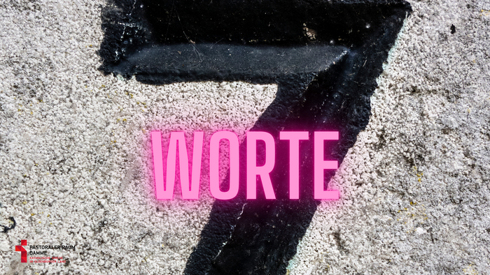 Nahaufnahme einer schwarzen Zahl sieben mit pinkfarbenem Text „WORTE“, der auf eine strukturierte Oberfläche gelegt ist.