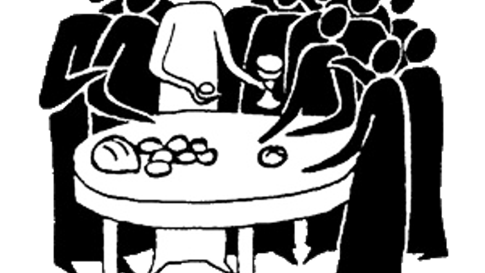 Eine Gruppe von Menschen sitzt um einen Tisch und isst.