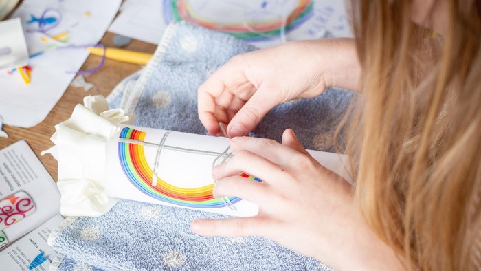 Bild eines Kindes, das eine Osterkerze bastelt