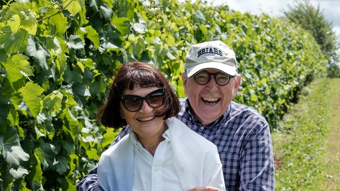 Ein Paar lacht vor Weinreben in einem Weinberg