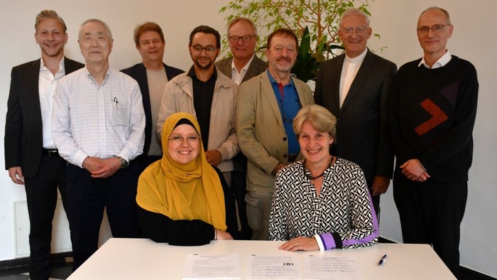 Ein gemischtes Team von Geschäftspartnern posiert für ein Gruppenfoto.