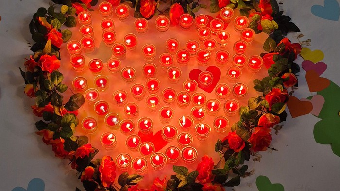 Ein Herz aus brennenden Kerzen.