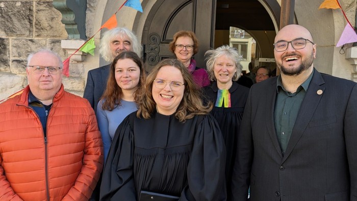 Gruppenfoto vor der Kirche in Guntershausen. Kirchenvorstandsmitglieder umrahmen Pfarrerin Anita Günther in der Bildmitte.