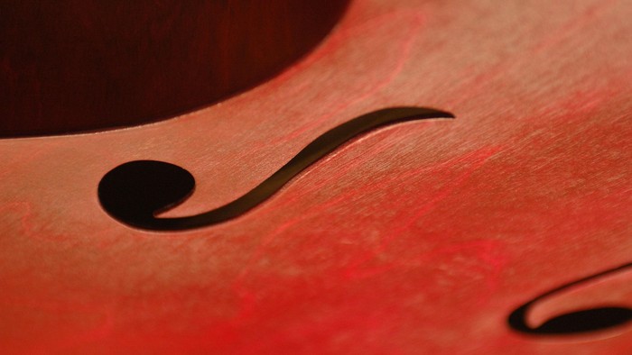 Nahaufnahme einer roten Geige mit schwarzen f-Löchern.