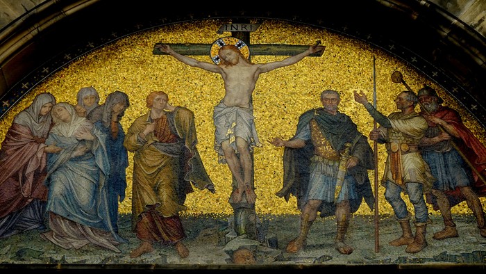Das Bild zeigt eine Mosaikkunst mit der Darstellung der Kreuzigung Jesu.