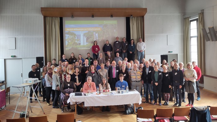 viele Menschen (ca. 70) im Saal für Foto aufgestellt