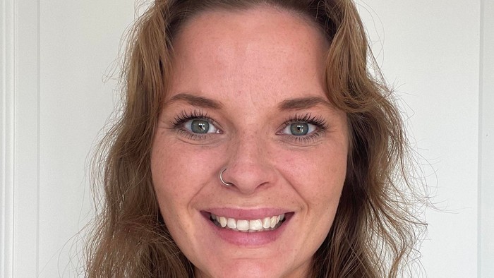 Portrætfoto af yngre kvinde med langt, bølget hår