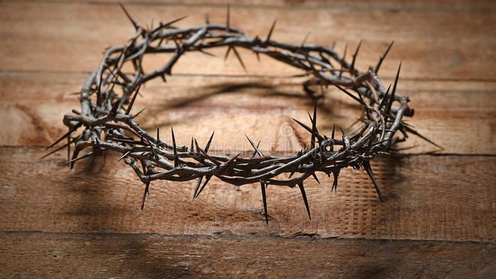 Ein Dornenkranz liegt auf einem Holzboden.