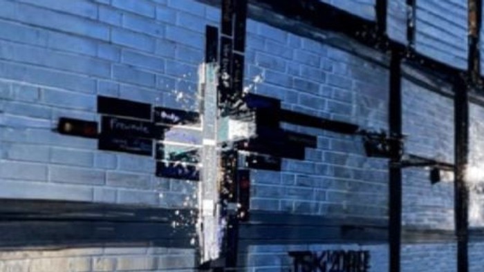 Grafitti-Kreuz vor einer Klinkerfassade