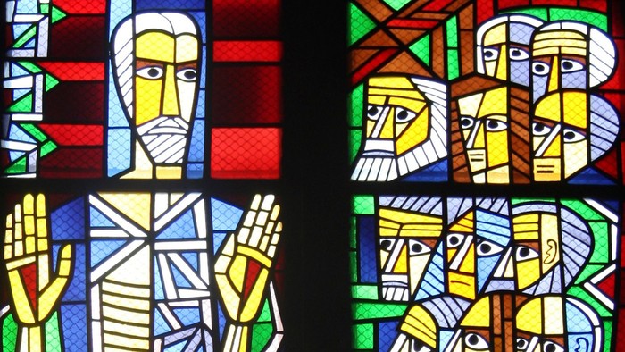 Buntes Kirchenfenster mit abstrakten Figuren.