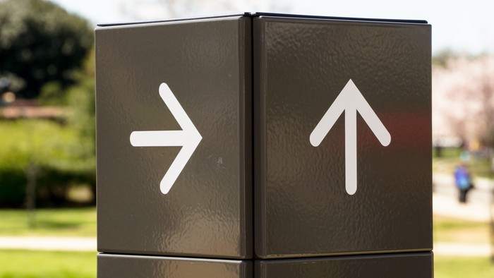 Moderner Wegweiser. Die beiden Pfeile zeigen in unterschiedliche Richtungen.