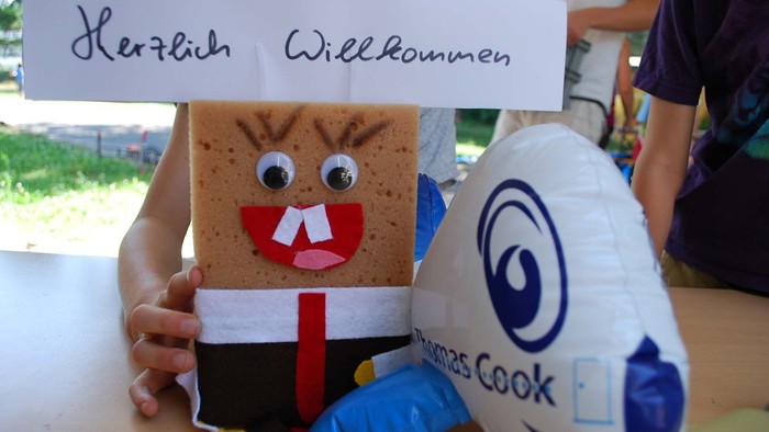 Herzlich Willkommen. Gebasteltes Arrangement mit Schwamm und Plastikflugzeug