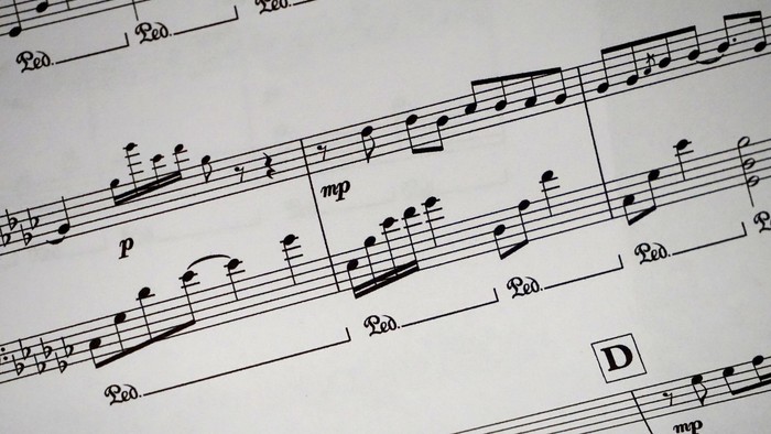 Nahaufnahme von Klaviernoten mit Pedal- und Dynamikangaben, darunter mezzo-piano- und forte-piano-Bezeichnungen.