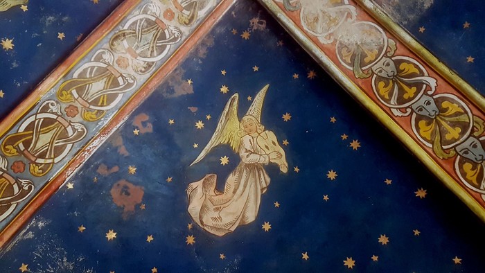 Komplexes Fresko, das eine engelhafte Figur vor einem sternenklaren, verzierten himmlischen Hintergrund darstellt.