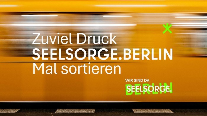 Eine unscharfe Zugwerbung, die Menschen auffordert, Post zu sortieren, mit dem Text *„Zu viel Druck? SEELSORGE.BERLIN Mal sortieren“*.