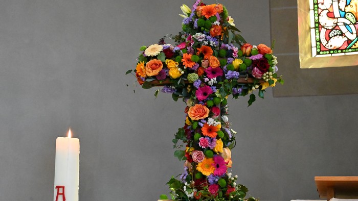 Hier sieht man ein Blumenkreuz auf dem Altar stehen