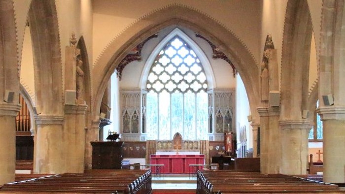 Interior of a large, old church with high arches and stained glass windows.