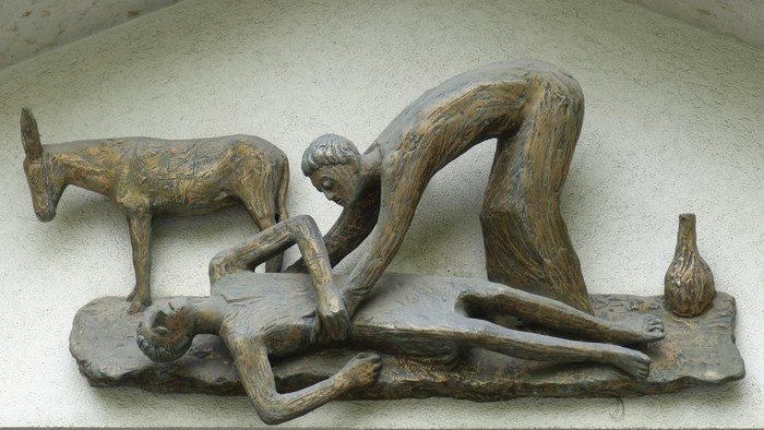 Bronzerelief zeigt einen knienden Mann neben einer gefallenen Figur, mit einem Esel in der Nähe und Werkzeugen.