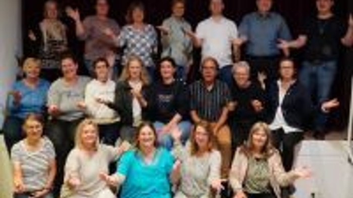 Ein großer Pulk von Menschen posiert für ein Gruppenfoto.