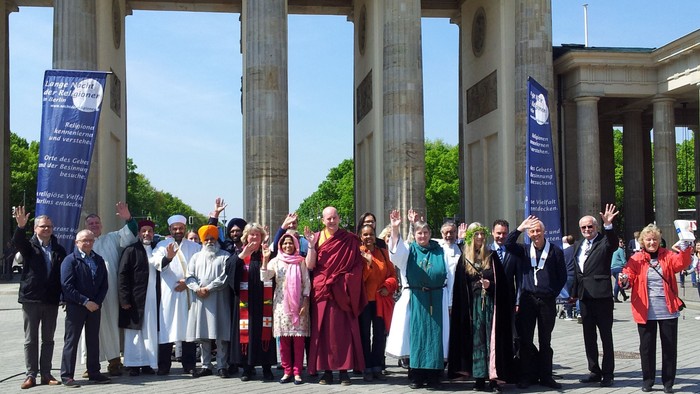 Eine Gruppe von Menschen posiert vor dem Brandenburger Tor