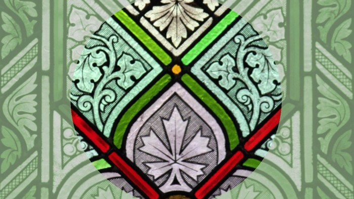 Komplexes Buntglas-Paneel mit floralen Mustern und geometrischen Bleistegen in leuchtenden Grün-, Rot- und Gelbtönen.