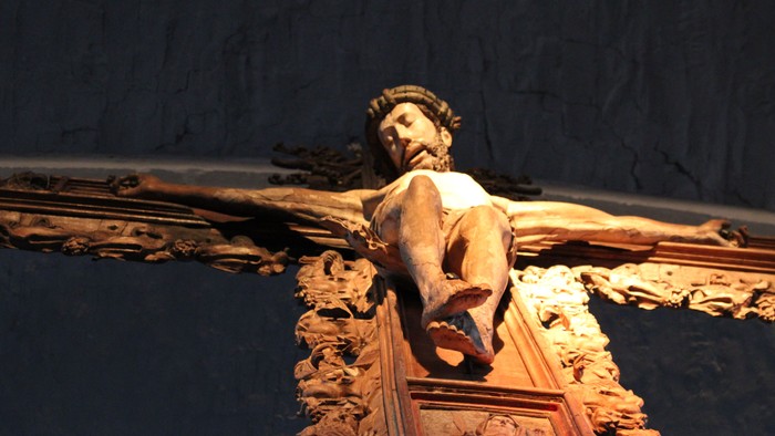 Die Statue eines Mannes mit Dornenkrone auf einem hölzernen Kreuz.