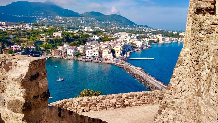 Blick von einem Aussichtspunkt auf Teile der Insel Ischia und eine Bucht im Meer
