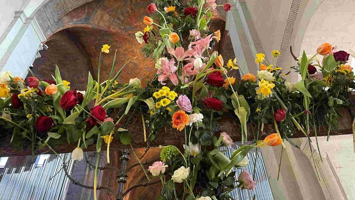 Prachtvolle Blumenarrangements in Kirche mit bunten Blumen und grünen Blättern