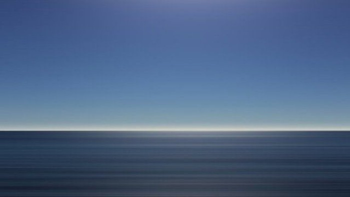 Ein ruhiges Meer bei Dämmerung mit dunklem Horizont und hellblauem Himmel.