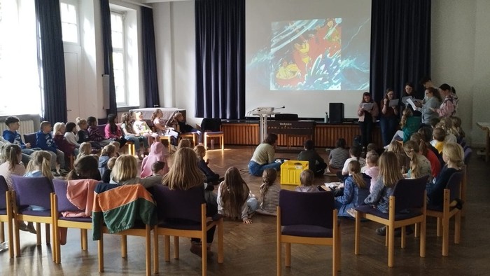 Kinder sitzen im Stuhlkreis