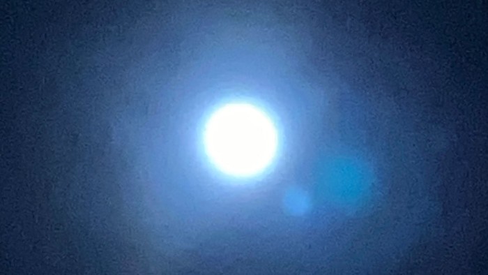 Helles Himmelsobjekt mit leuchtendem blauem Halo und umgebendem diffusem Licht im Weltraum.