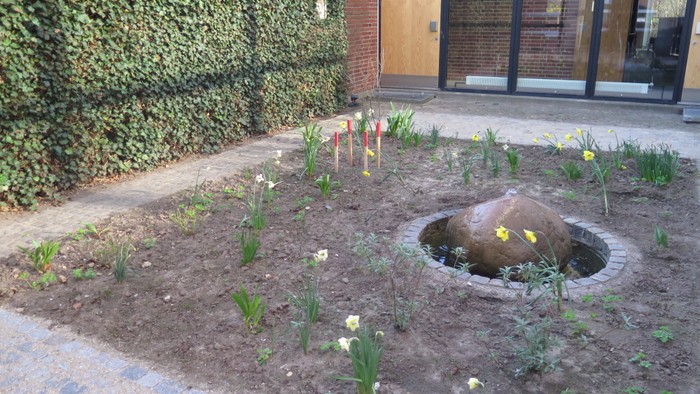 4 røde pinde sat i jorden i atriumgården