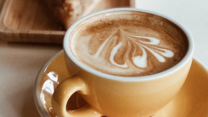 Zwei Tassen Kaffee und ein Stück Kuchen auf einem Tisch