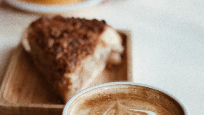 Zwei Tassen Kaffee und ein Stück Kuchen auf einem Tisch