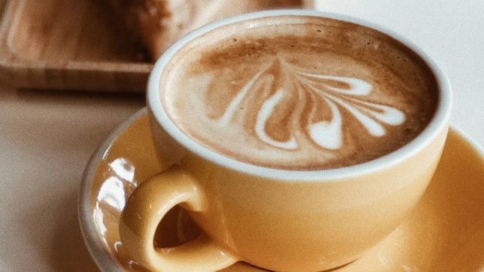 Zwei Tassen Kaffee und ein Stück Kuchen auf einem Tisch