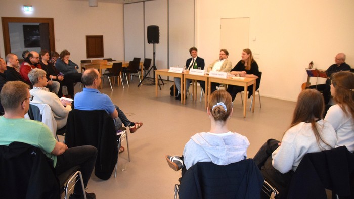 Bild vom Dialogforum Verständigungsorte. Auf dem Podium Isabelle Vandre, Benjamin Lassiwe und Prof. Paul Silas Peterson (v. r. n. l.)