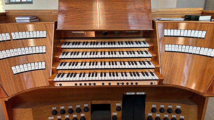 Elegante Holzpfeifenorgel mit mehreren Manualen und Spielpedalen in einem prächtigen Ambiente.