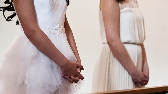 Konfirmander ved alteret med foldede hænder