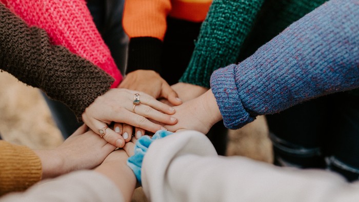 Viele Menschen legen ihre Hände ineinander