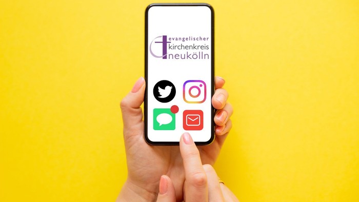 Hände halten ein Smartphone, das Social-Media-Symbole und das Logo einer evangelischen Kirche aus Neukölln anzeigt.