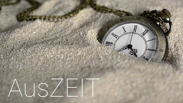 Eine Taschenuhr liegt seitlich im Schnee, die Kette erstreckt sich nach außen.
