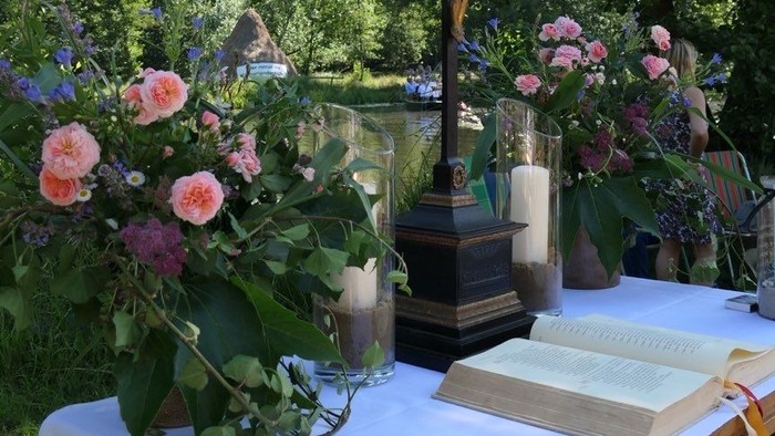Ein Tisch mit Blumen und einem Buch unter Bäumen