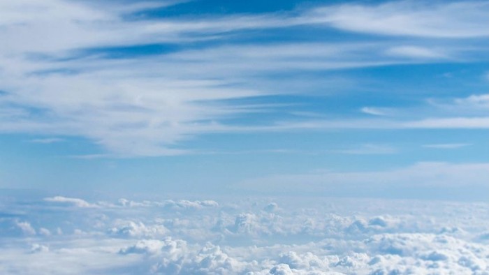 Weites Himmelsgewölbe, gefüllt mit flauschigen weißen Wolken vor einem strahlend blauen Hintergrund.