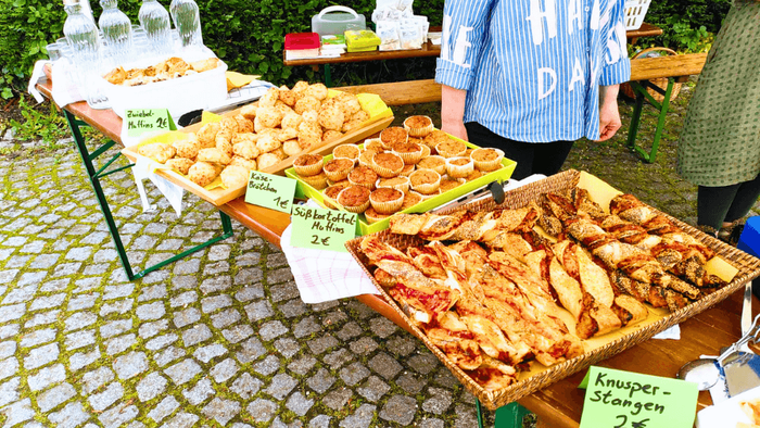 Auf dem Tisch stehen viele Tabletts mit Muffins und