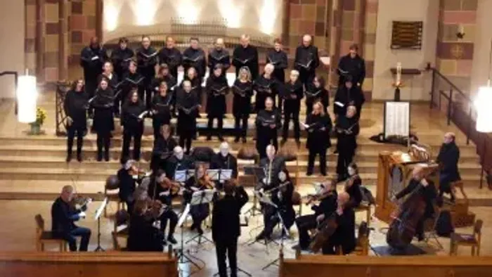 Ein großer Chor und ein Orchester treten gemeinsam in einer prächtigen Holzkirche auf.