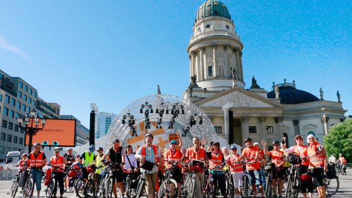 Eine Gruppe von Radfahrern posiert vor dem Gendarmenmarkt in Berlin