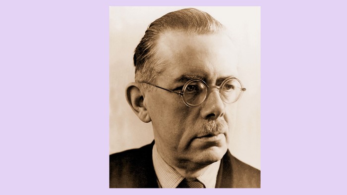 Ein älterer Mann mit Brille und Anzug.