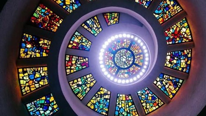 Bekanntmachung für einen Gottesdienst mit farbenfrohem Spiralmuster aus Buntglas, geplant am 21. und 28. Juni 2026.